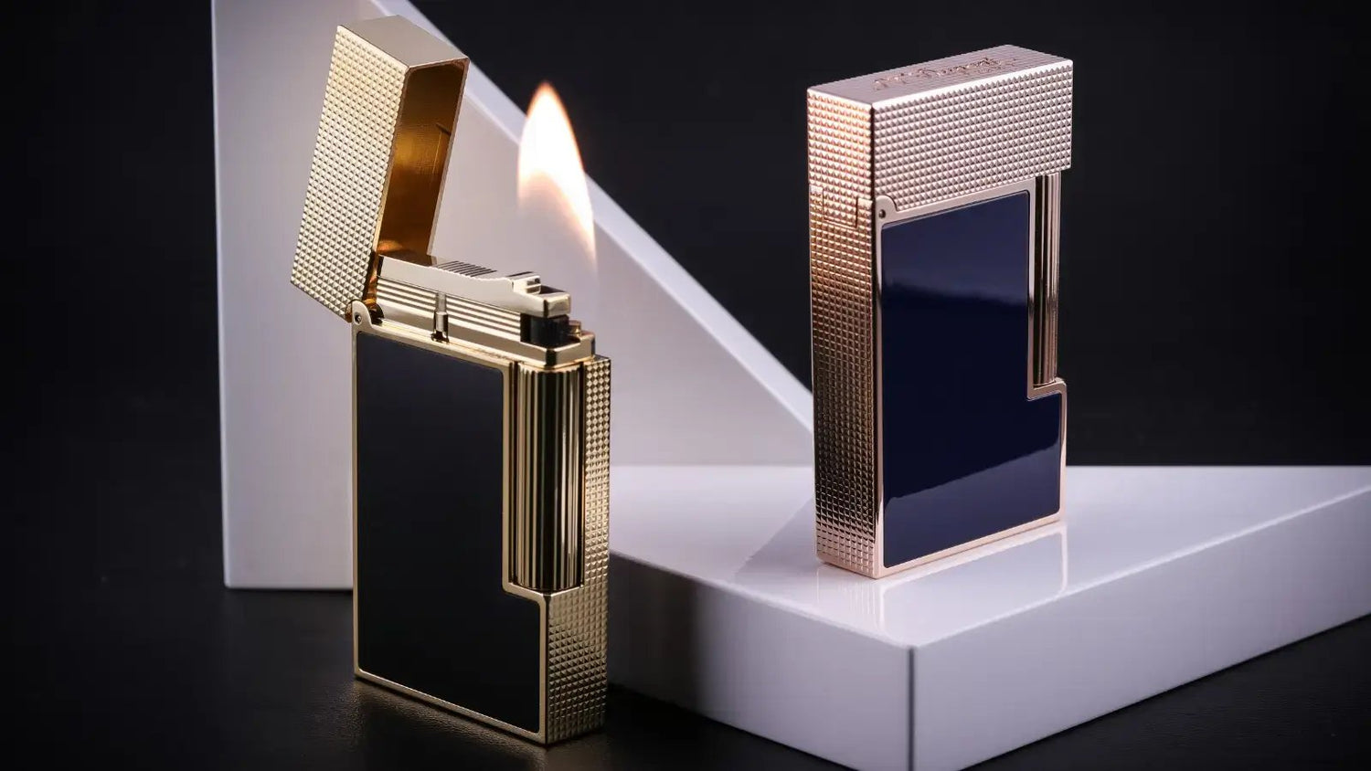 S.T. Dupont LIgne 2 lighters with matte black lacquer and gold finish, and blue lacquer with rose gold finish.