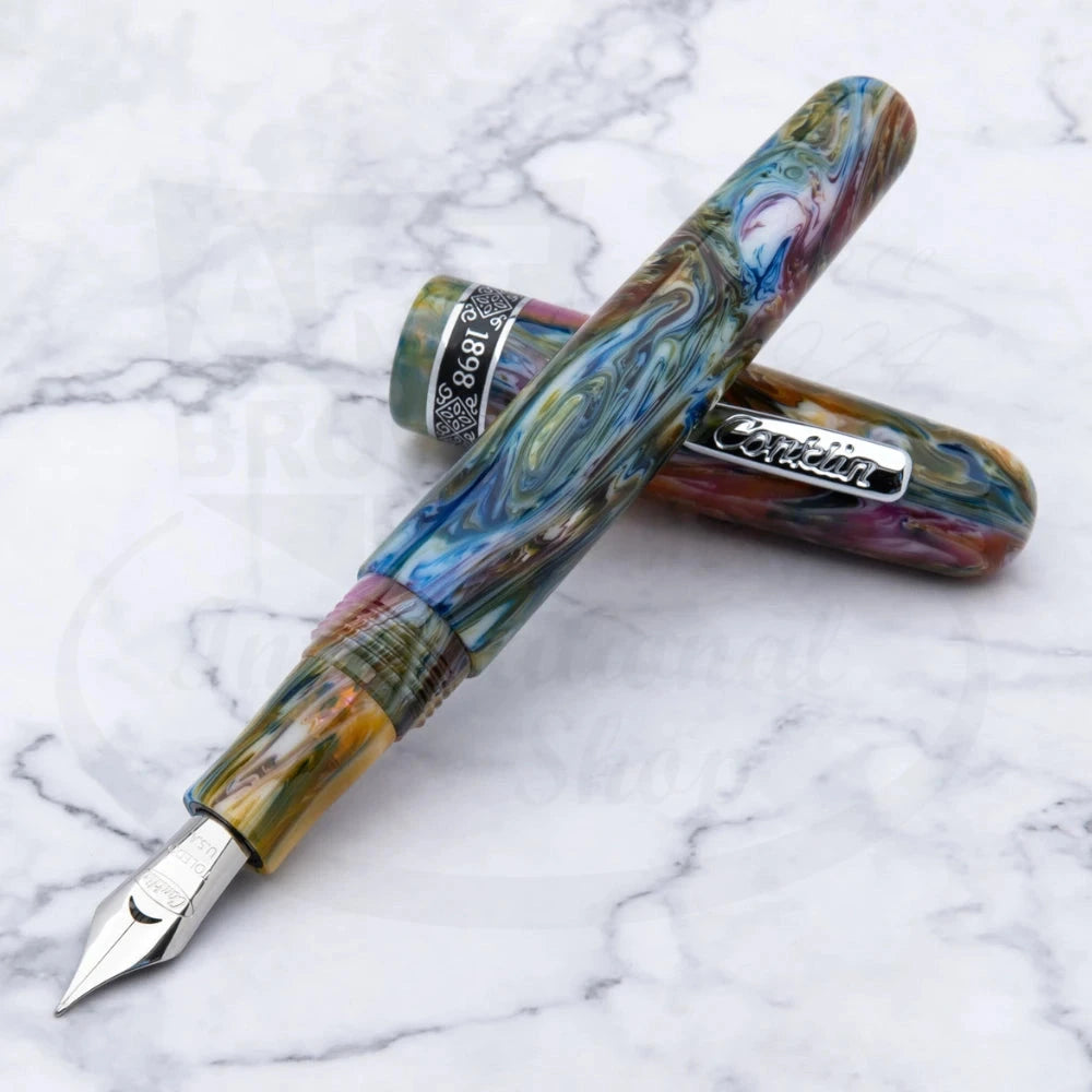 Conklin 1898 Misto Green Fountain Pen shown open on a white marble surface, highlighting its vivid marbled pattern and polished silver details.