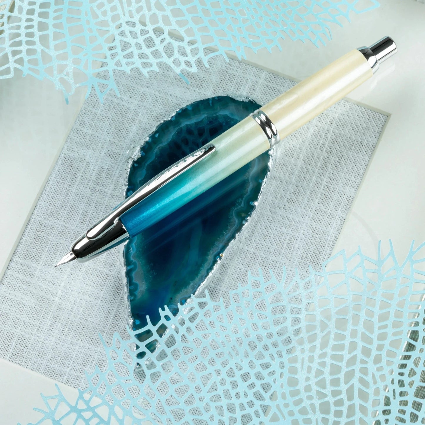 Close-up of the 2024 Limited Edition Pilot Vanishing Point Seashore fountain pen with chrome details on a geode display